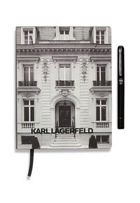 Fekete-fehér notesz, amelyen egy kast�ély homlokzata látható. A szöveg így szól: "KARL LAGERFELD." Mellette egy fekete toll található.