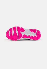 Semelle de chaussure avec une base blanche et des accents en caoutchouc rose texturé en motif de vagues pour une meilleure adhérence et traction.