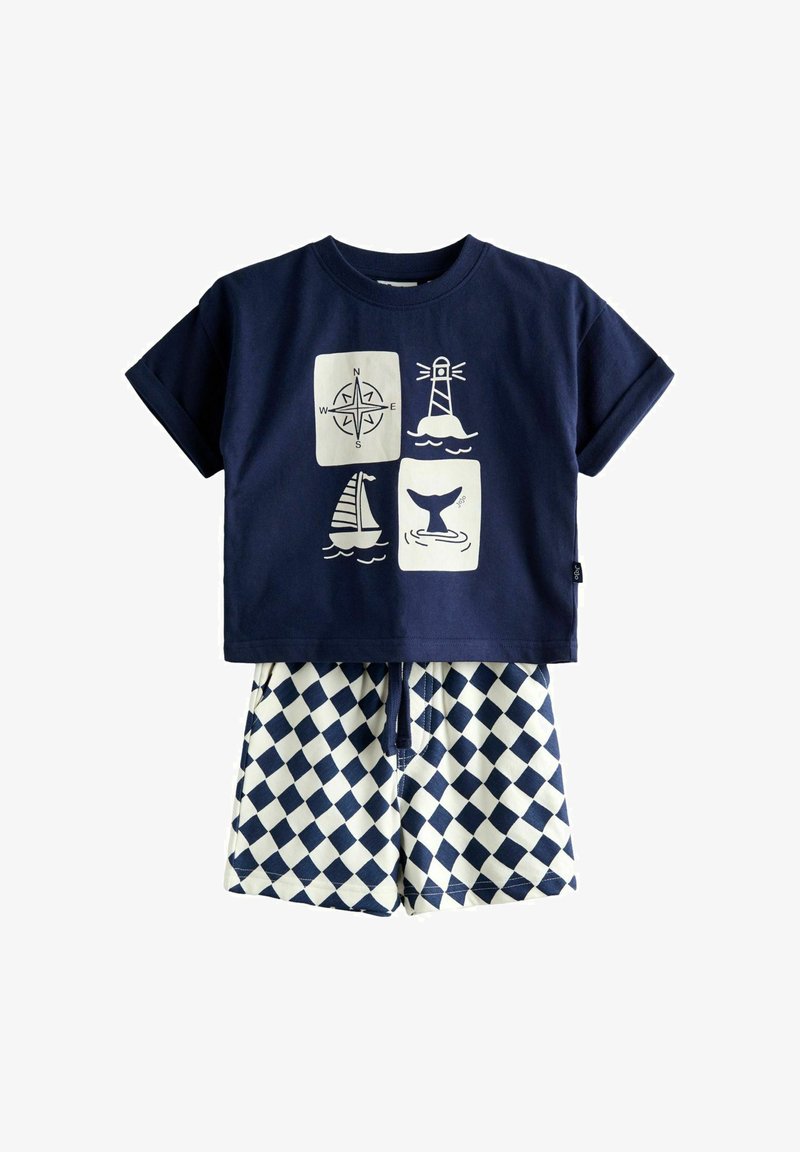 T-shirt bleu marine avec des icônes nautiques blanches et un short à carreaux bleu et blanc, conçu pour une tenue d'été d'enfant.