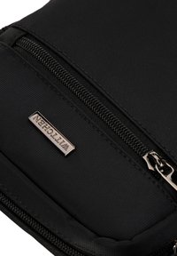 Pochette in tessuto nero con chiusura a zip, decorata con una placcatura del marchio in tono argento e una finitura texturizzata.