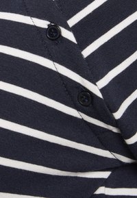 Navyblauer Cardigan mit weißen Horizontalstreifen, rundem Ausschnitt und einem schwarzen Knopfverschluss vorne. Glatte Textur.