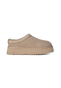 Beige slip-on shoes with suede upper, a braided tan accent around the collar, and a thick, textured platform sole with a serrated edge.