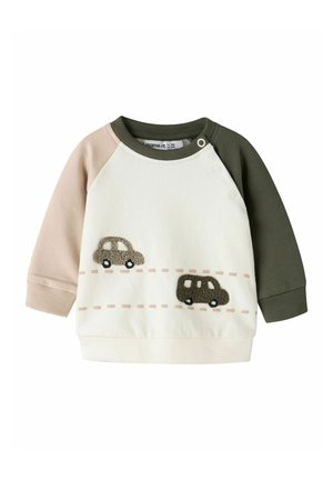 Bluza niemowlęca z jednym beżowym rękawem, jednym ciemnozielonym rękawem, białym tułowiem i dwoma materiałowymi samochodzikami z misiami na przodzie z przerywanymi liniami.