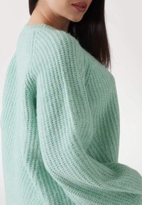 Mintgrüner Strickpullover mit einem strukturierten, gerippten Design. Mit locker sitzenden Ärmeln und einem runden Ausschnitt. Weicher, gemütlicher Stoff.