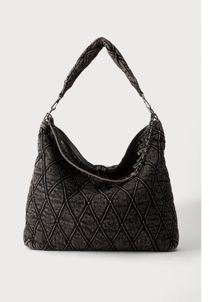 Sac à main noir matelassé avec de grandes coutures en forme de losange, poignée rembourrée et fermeture éclair, présenté sur un fond clair uni.