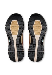 Vedere a profilului tălpii a unei perechi de pantofi de drumeție bej și negri, cu tălpi groase și robuste, concepute pentru aderență și durabilitate.