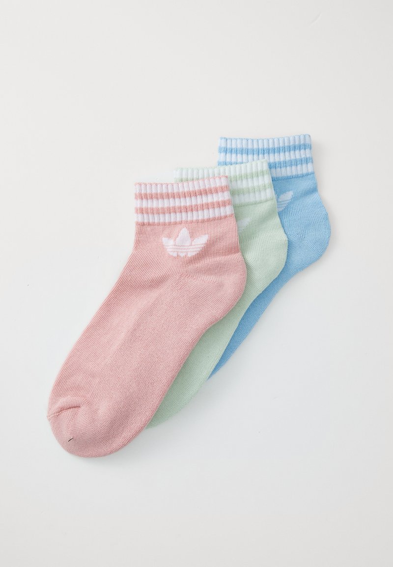 Três pares de meias de cano curto nas cores rosa, verde e azul, cada uma com punhos canelados listrados e um logotipo branco no lado exterior.