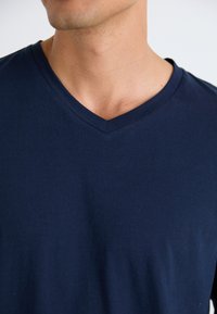 Marineblauwe katoenen t-shirt met een v-halsontwerp, korte mouwen en een gladde textuur. Casual pasvorm zonder zichtbare patronen of accenten.