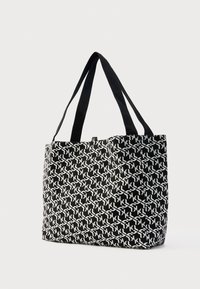 Taška typu tote z čierno-bielej látky s geometrickým vzorom. Má dve pevné čierne popruhy a štruktúrovaný tvar.