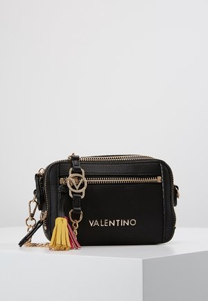 Borsa a tracolla in pelle nera con hardware dorato, dettagli con cerniera, logo impresso e un accento di nappina colorata in rosa, giallo e rosso.