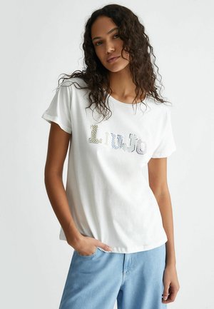 T-shirt bianca in cotone con maniche corte e scollo rotondo. Presenta il lettering in paillettes "LiuJo" con accenti multicolore.