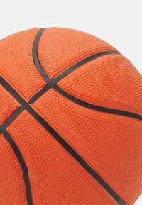 Orange basketball with textured surface, featuring raised bumps and black grooves forming a classic design pattern.