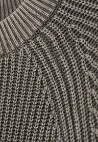 Pull en tricot gris foncé avec col côtelé contrastant gris clair. Présente une finition texturée avec un motif diagonal. Matière douce.