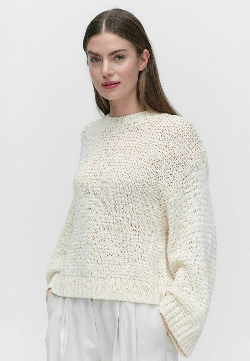 Wit gebreid sweater met een gestructureerde afwerking, ronde halslijn en verlaagde schouders. Ribgebreide zoom en manchet. Lichtgewicht en losvallend model.