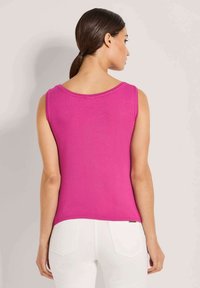 Enganliegendes ärmelloses Oberteil in leuchtendem Pink, aus weichem Material gefertigt. Verfügt über einen runden Halsausschnitt und einen geraden Saum. Rückansicht gezeigt.