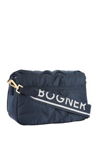 Borsa trapuntata blu navy con accessori in oro, una tracolla a strisce a contrasto con la scritta "BOGNER" e una finitura morbida e opaca. Forma rettangolare compatta.
