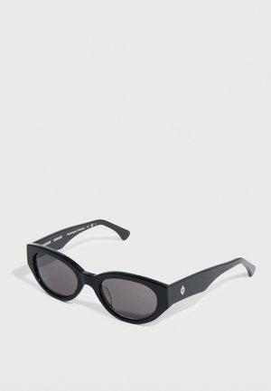 Black cat-eye sunglasses with a glossy finish. Features dark lenses, thick frames, and slight branding on the temples.