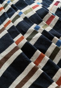 Strickstoff mit horizontalen Streifen in Marineblau, Creme und mehreren Farben (Grün, Rot, Blau, Orange, Braun) mit strukturiertem Gewebe.