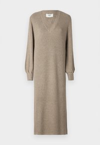 Beige neulemekko, jossa on V-pääntie ja pitkät, puffihihat. Sen pinnassa on ribbaustekstuuri ja suora, polvipituisen siluetti.