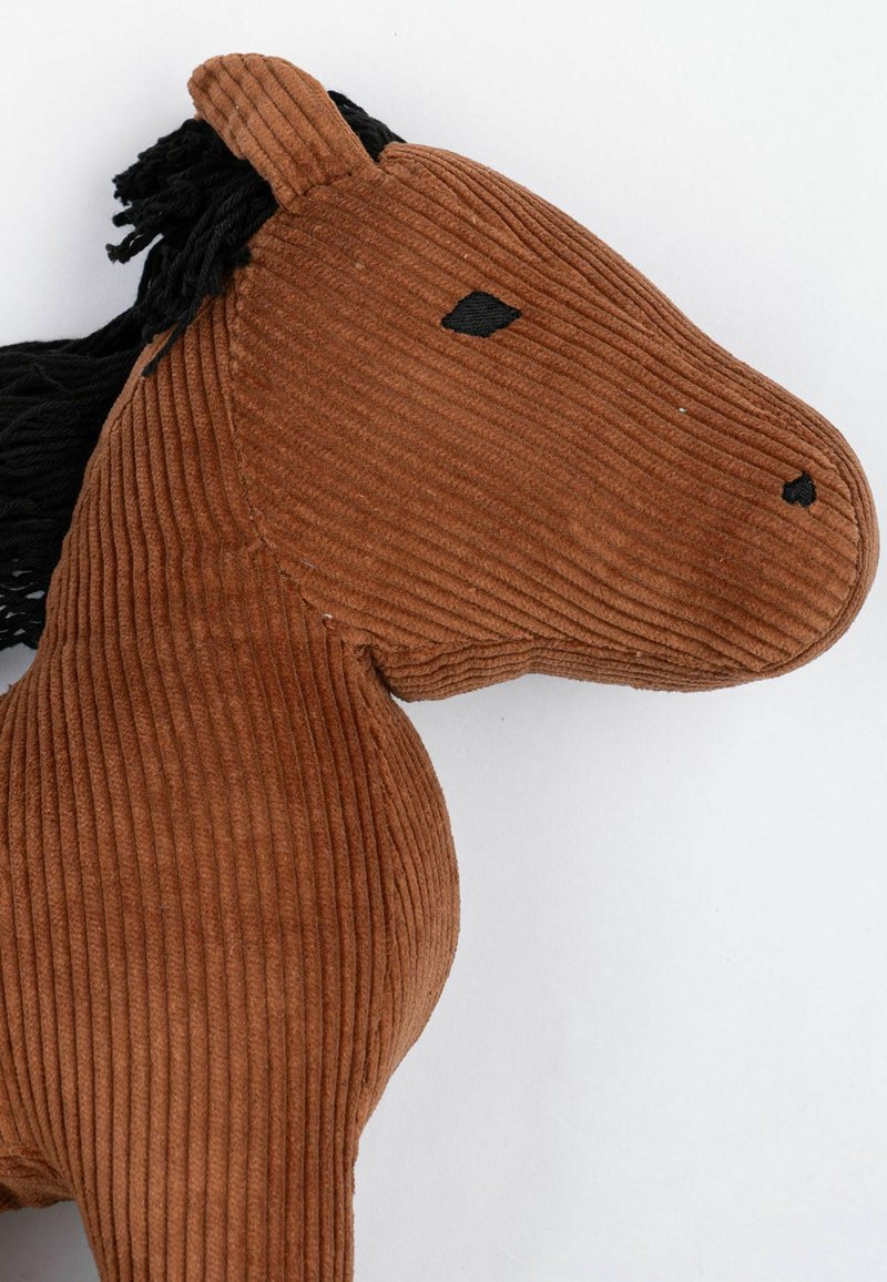 Plüschpferdchen aus braunem Cordstoff, das eine strukturierte Oberfläche hat, mit einer Mähne aus schwarzem Garn und einfachen, schwarz gestickten Augen.