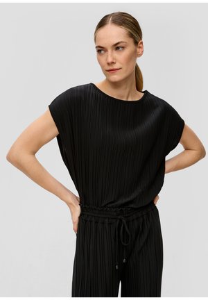 Combinaison noire plissée à manches courtes et taille élastique avec cordon de serrage. Tissu lisse et texturé avec une coupe décontractée.