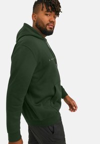 Mørkegrøn hoodie lavet af blødt stof, med en front kangaroo-lomme og ribbede manchetter, med "JACK & JONES" logo i hvid på brystet.