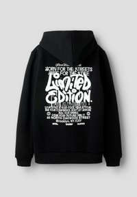 Czarna bluza z kapturem z białym tekstem w stylu graffiti, na którym widnieje napis "Limitowana Edycja" oraz motywacyjne frazy, z adresem Brooklyn, NY, na plecach.