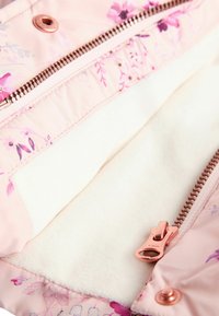 Interiorul jachetei de un roz deschis, cu un model floral, căptușit cu un alb moale și cu accesorii din aur roz. Textură netedă, design funcțional.