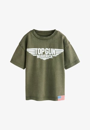 Maslinasto zelena majica kratkih rukava sa bijelim natpisom "TOP GUN MAVERICK" i logotipom krila, te malom zakrpom američke zastave blizu ruba.
