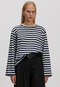 Gestreiftes langärmliges Hemd aus navy und weißem Stoff, mit lockerer Passform, Rundhalsausschnitt und leichtem Fall am Saum.
