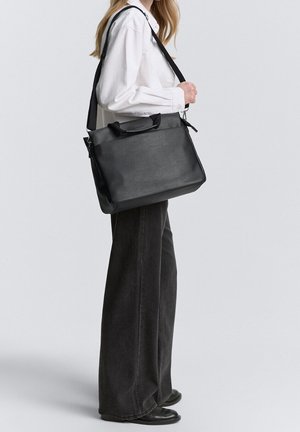 Black leather handbag with a rectangular shape, top handles, and a detachable shoulder strap. Smooth texture and minimalistic design.