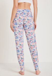 Bloemenleggingen met een blauwe achtergrond en roze, oranje en witte bloemen. Gemaakt van een zachte, rekbare stof, met een aansluitend ontwerp.