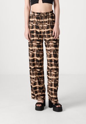 Pantalons ample en noir et beige avec un motif abstrait, dotés d'une taille à cordon de serrage et d'un tissu léger pour le confort.