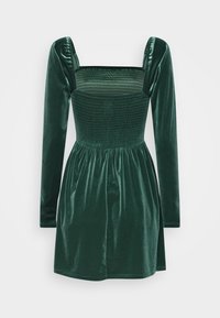 Robe en velours vert avec un décolleté carré, des manches longues bouffantes et un corsage smocké, s'évasant en une jupe froncée. Texture lisse sur toute la surface.