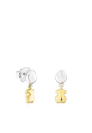 Orecchini in argento e oro con un ciondolo a forma di orso. Finitura lucida con una superficie liscia, pendono da un perno rotondo.