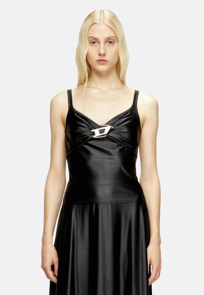 Abito nero elegante in materiale sintetico con corpino aderente e gonna svasata. Presenta un design frontale intrecciato e un dettaglio con fibbia metallica.