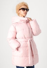 Cappotto puffo rosa con vita cinturata, grande cappuccio e design trapuntato. Presenta maniche oversize e tasche frontali. Texture liscia e lucida.