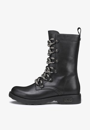 Stivale alto in pelle nera con ganci metallici ai lacci, lacci testurizzati e una suola in gomma robusta. Presenta un anello sul retro per una facile vestibilità.