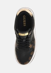 Sneaker neri con accenti dorati e un logo. Presenta un lato a motivo marrone, design con lacci e suola bianca. Tessuto nero texturizzato.