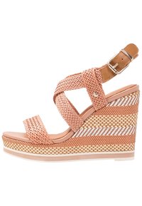 Sandale à semelle compensée avec des sangles tissées beige et pêche, boucle de cheville, et talon compensé texturé multicolore avec des rayures blanches, beige et pêche.