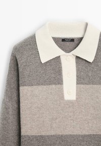 Pull en jersey rayé gris avec un col polo crème. Comprend une patte de boutonnage à trois boutons, une texture douce et des nuances de gris variées en bandes horizontales.