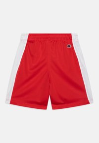 Shorts da atletica in rete rossa con pannelli laterali bianchi, cintura elasticizzata e logo "Champion" sul lato sinistro.