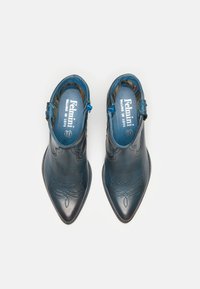Botas de cuero azul hasta el tobillo con punteras afiladas, patrones de costura decorativos y cierre de cremallera lateral. Acabado de cuero texturizado con un interior suave.
