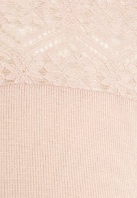 Tecido rosa claro com uma parte superior de renda texturizada adornada com padrões florais intrincados, acima de uma seção suave canelada.