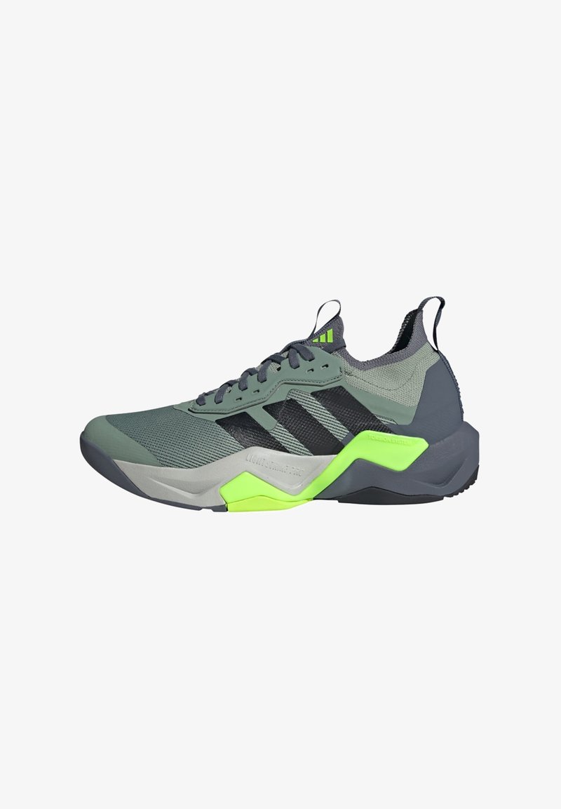 Scarpa sportiva con tomaia in mesh verde e grigio, caratterizzata da strisce nere e un accento verde brillante sul tallone. Punta arrotondata, superficie testurizzata.