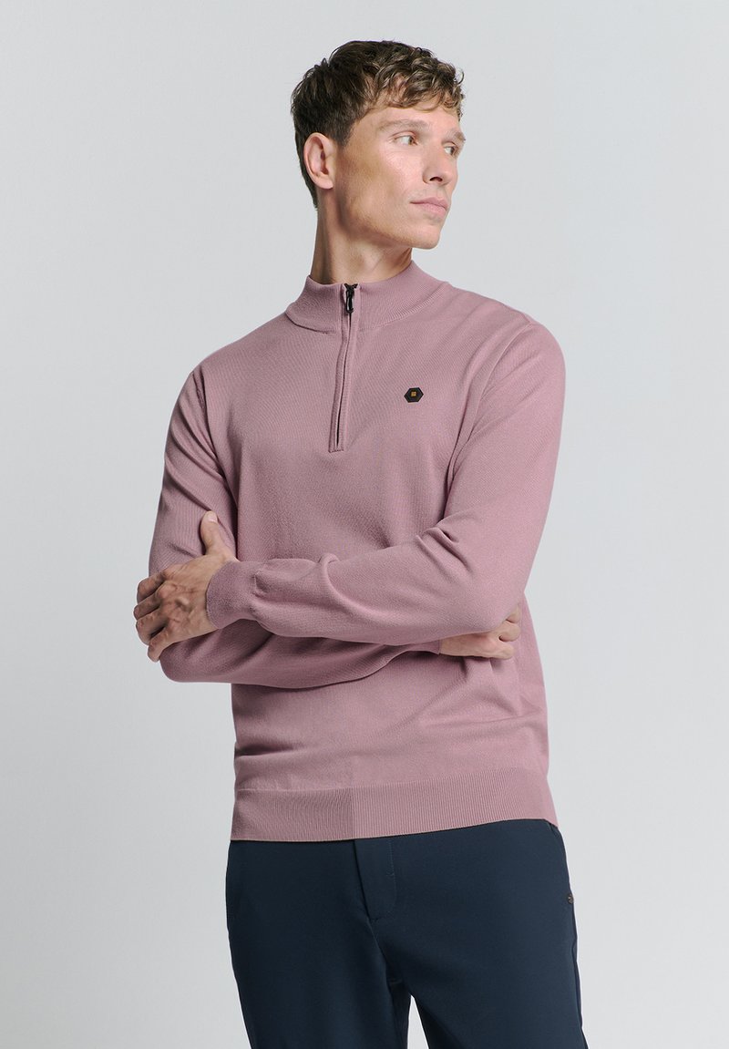 Lichtroze, pullover met ritssluiting gemaakt van gestructureerde stof. Heeft lange mouwen, geribbelde manchetten en een klein hexagonaal logo op de borst.