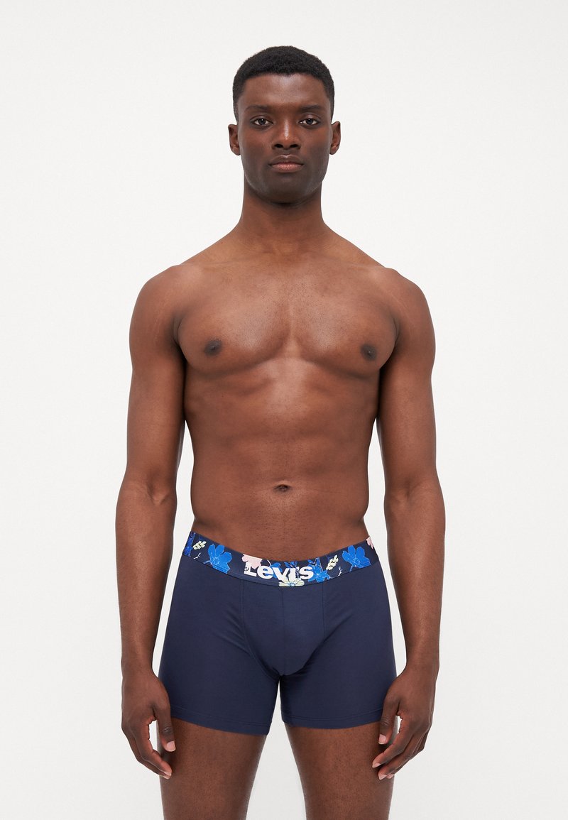 Bóxer azul marino fabricado con tela suave, con una cinturilla de patrón floral que lleva el logo de "Levi's" en blanco. Diseño liso y ajustado.