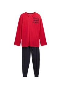 Chemise rouge à manches longues avec texte noir ; associée à un pantalon sombre avec des poignets fuselés. Tissu doux ; coupe décontractée.