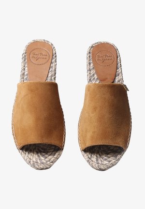 Sandales en daim marron à enfiler avec des semelles en corde tressée et une semelle intérieure en cuir lisse portant un logo. Design ouvert aux orteils avec des bords supérieurs arrondis.