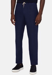 Marina linnebyxor med dragsko i midjan, raka ben, sidfickor och matchade med svarta slipskor.